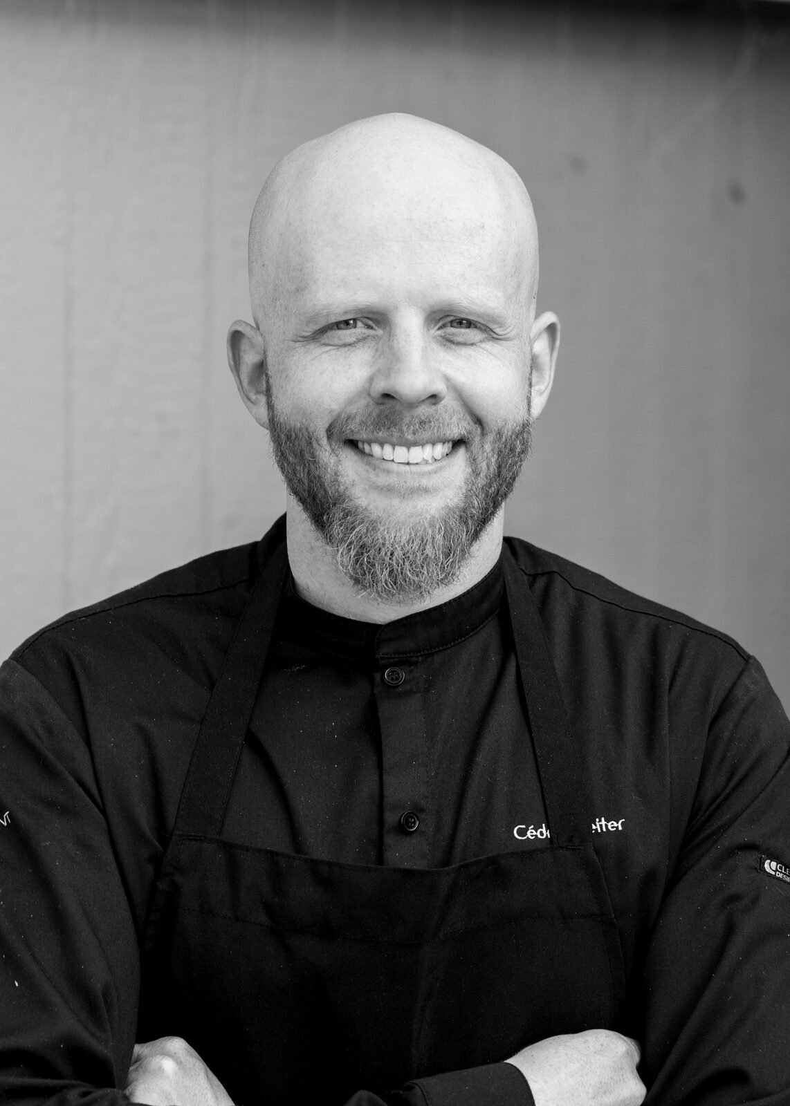 Chef Cedric Reiter in chef's whites and a black apron